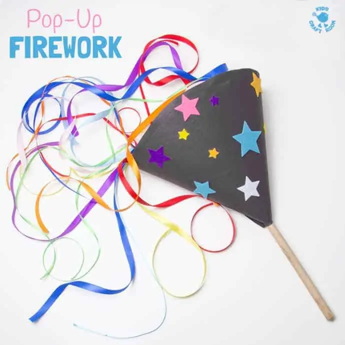 A pop up firework toy lying on its side on a white background. The colourful ribbon streamers are bursting out of the top to make a firework display.