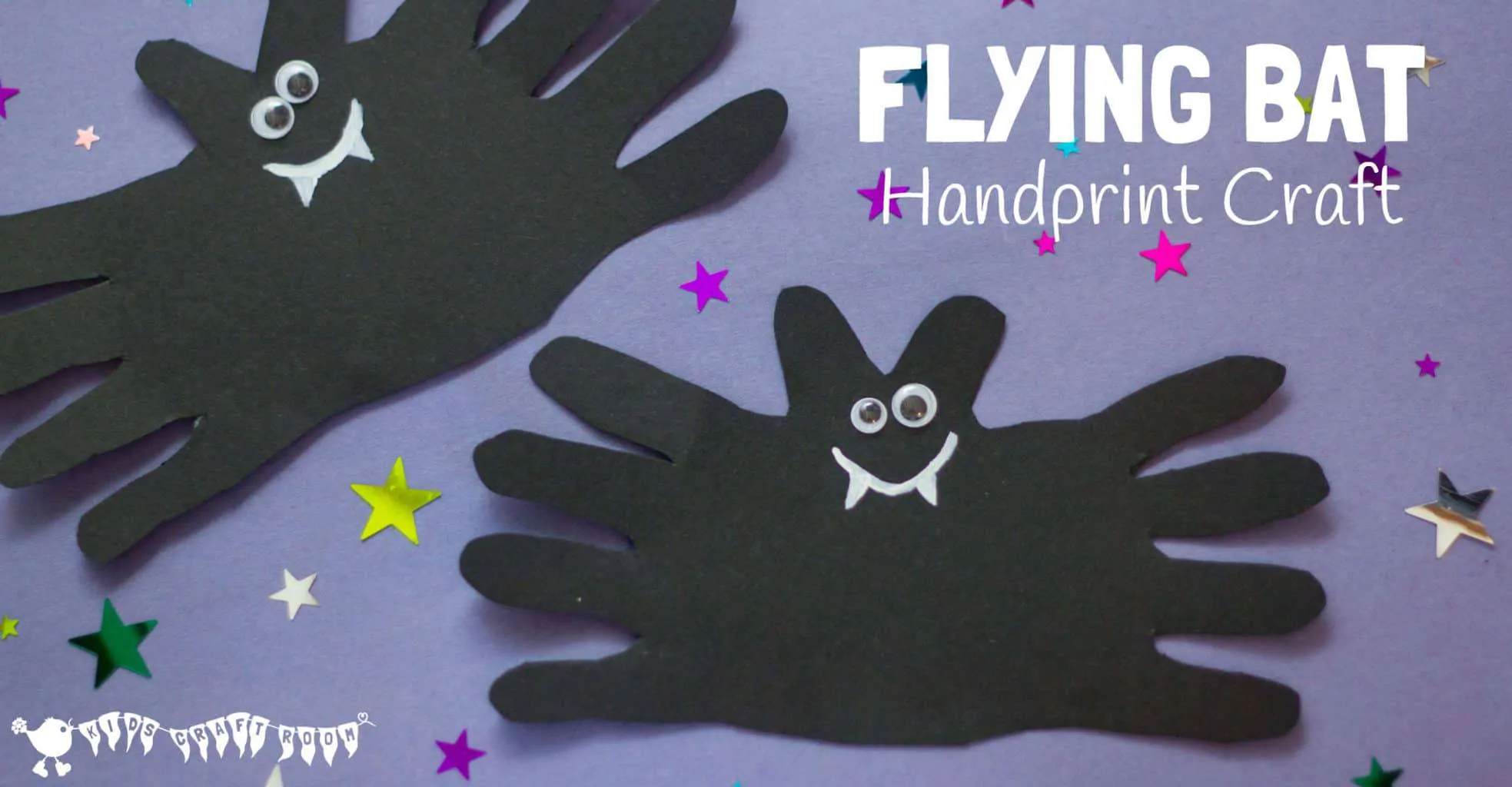 Two Halloween bat crafts made from black paper and handprints. The fingers make the wings and the thumbs make the ears. They have googly eyes and a white smile with fangs.