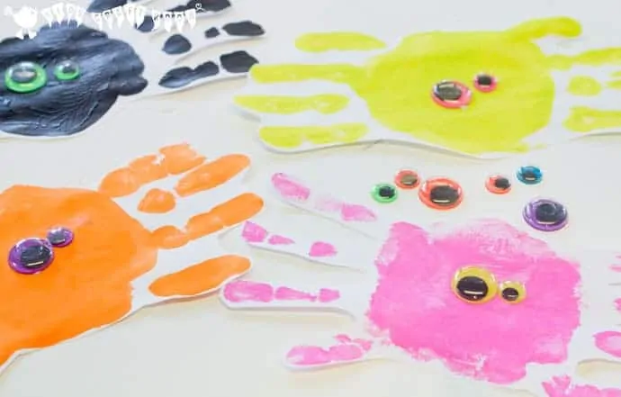 Adding features to cute handprint spiders. Handprint Spiders In Webs are easy & frugal to make and a super way to build fine motor threading skills. A fun spider craft for Halloween & all year round.
