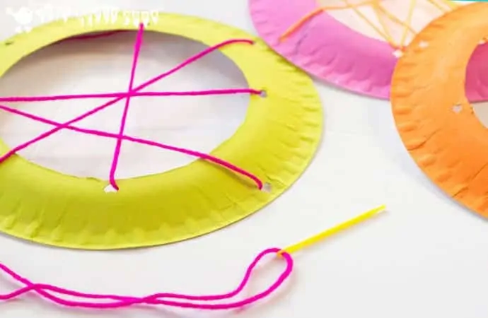Weaving Paper plate Webs - Handprint Spiders In Webs are easy & frugal to make and a super way to build fine motor threading skills. A fun spider craft for Halloween & all year round.