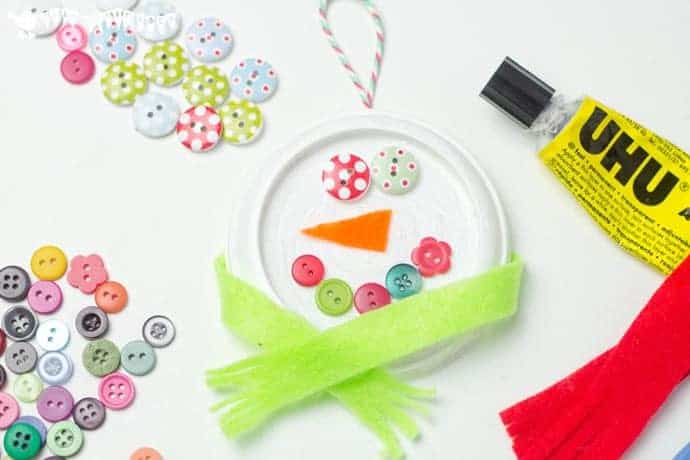 With their button eyes and snug scarves these are the cutest snowman ornaments for kids to make this Christmas. A thrifty recycled Christmas craft for kids.