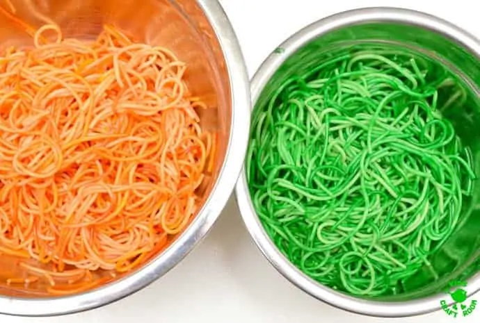 PREPARING WITCH'S POTION HALLOWEEN SENSORY PLAY IDEA. Orange and green pasta.