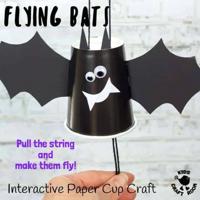 A close up of a Flying Bat Craft For Kids showing how to pull the string to make it fly.