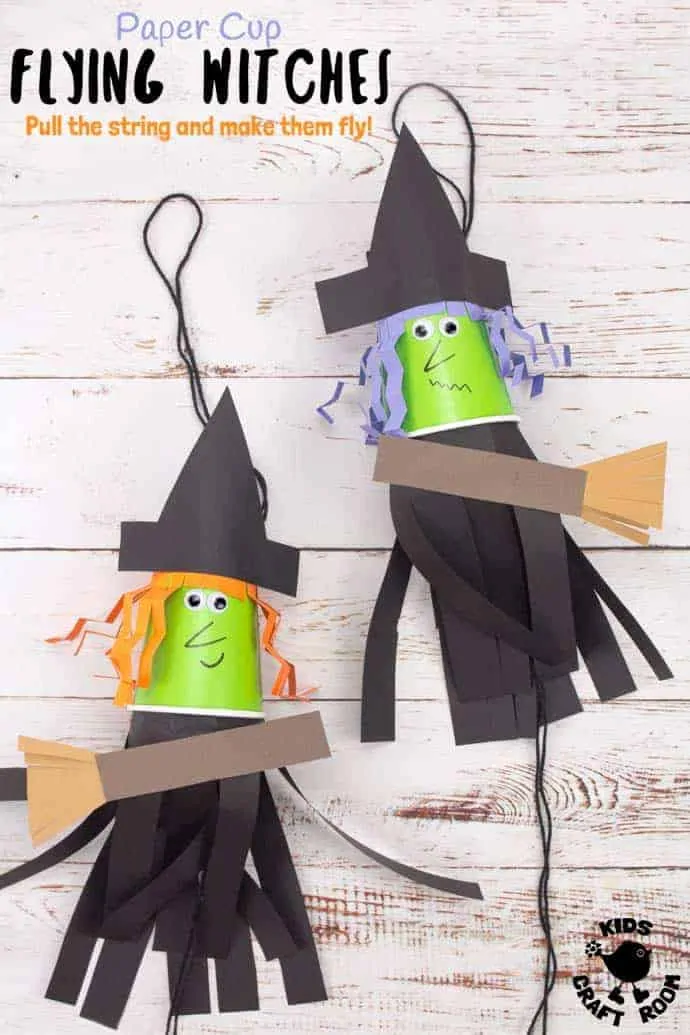 Two Flying Paper Cup Witch Craft For Kids. The faces are made from paper cups. They have strips of black paper stuck inside and hanging down to make the dresses. The witch on the left has orange hair and the witch on the right has purple hair. 