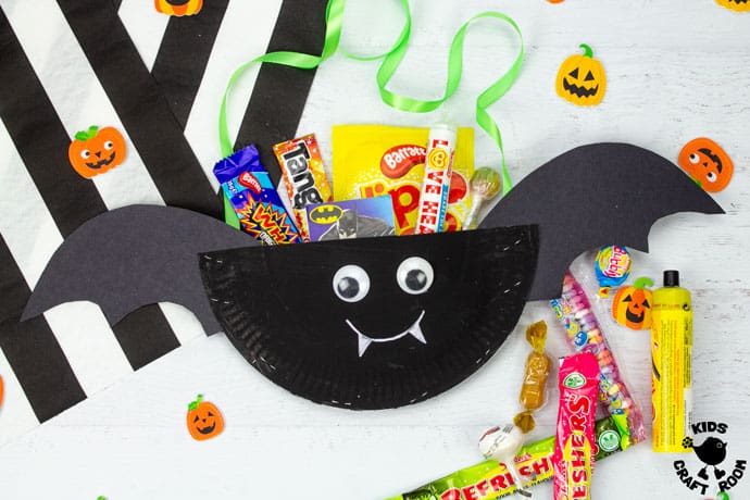 Halloween Bat Treat Bag on a white table top with sweets spilling over the top of it.