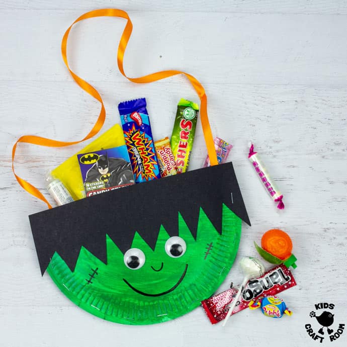 Paper Plate Frankenstein Treat Bag filled with sweets, on a white table top.