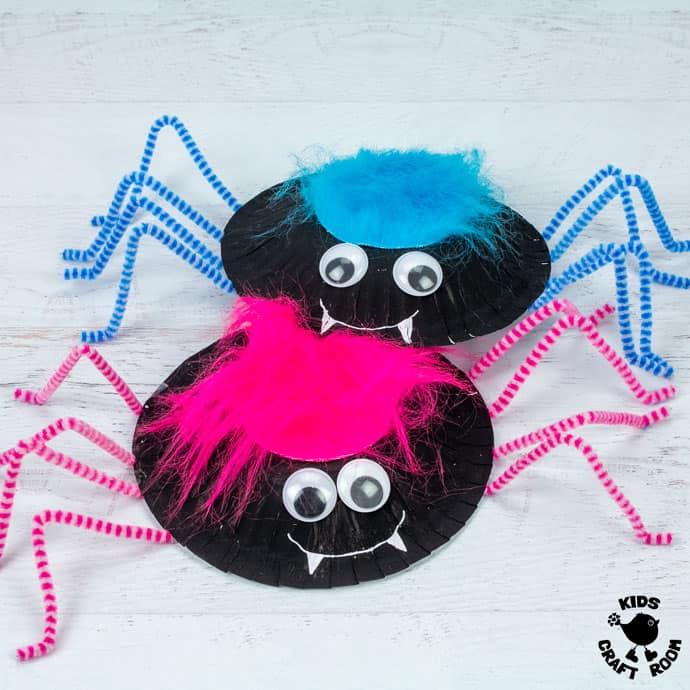 2 Hairy Spider Crafts with blue and pink hair on a white table top. 