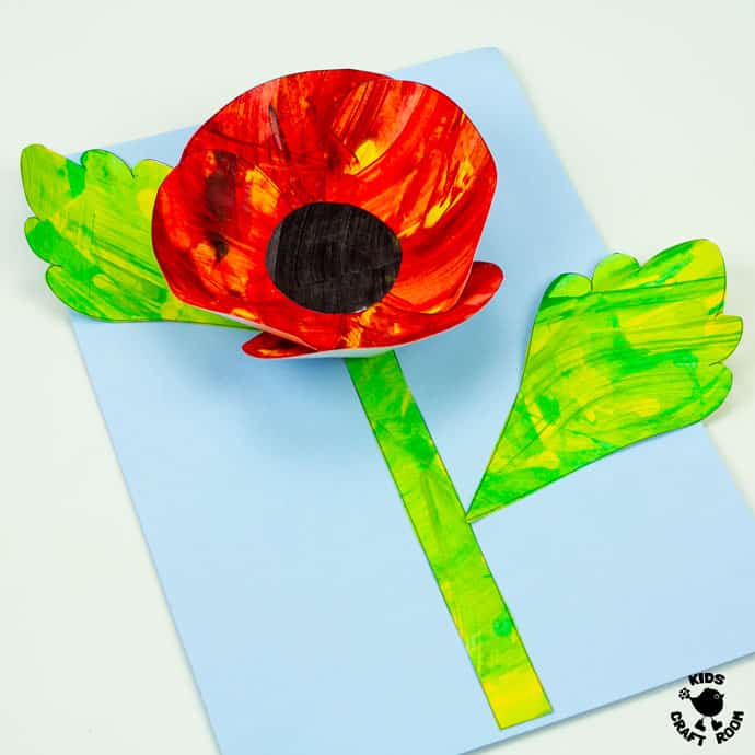 Scrape Painted Poppy Craft lying off centre on a white table top. Square image.
