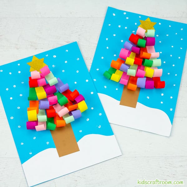 A square image showing 2 Curled Paper Christmas Tree Crafts lying on a white table top, one slightly overlapping the other.