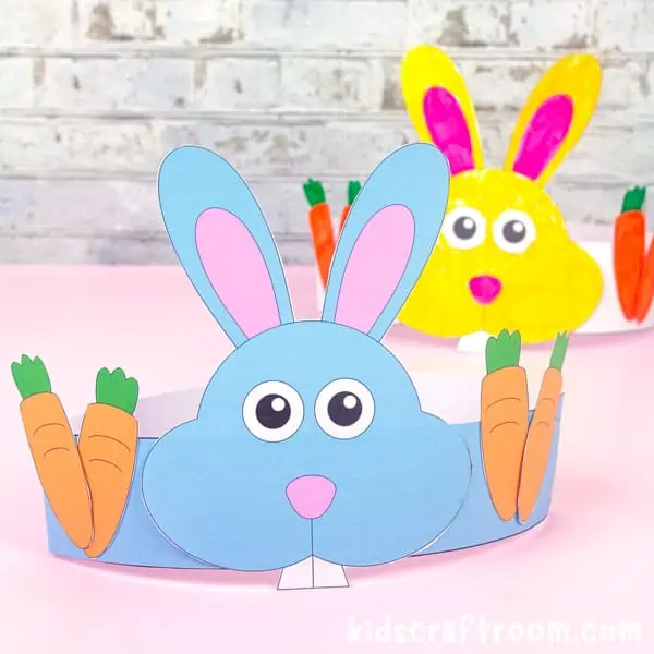 A blue and yellow Easter Bunny hat on a pink table top.