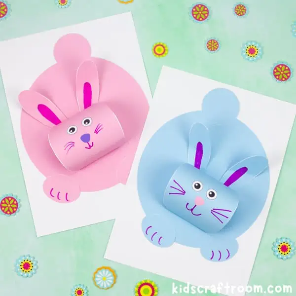 A pink and blue 3D Chubby Bunny Craft, lying side by side on a green tabletop.
