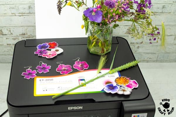 Flower jewellery and a vase of flowers on a printer.