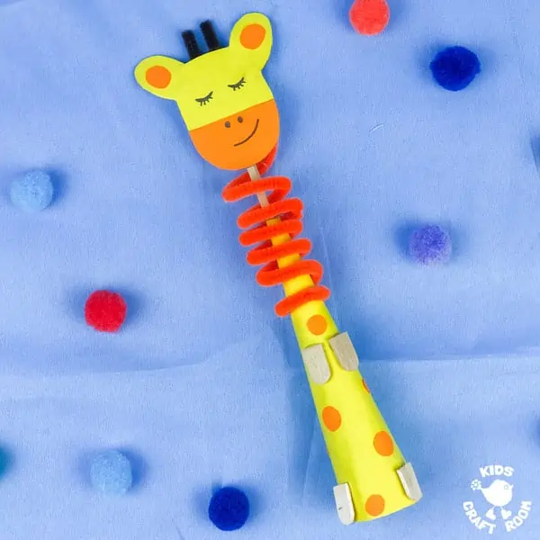A Paper Cone Giraffe Craft lying on its back on a blue cloth.