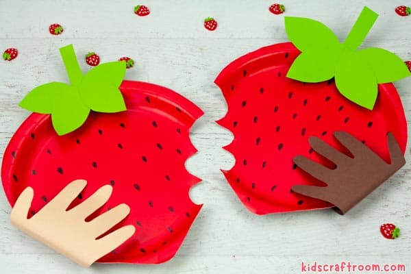 Two Paper Plate Strawberry Crafts lying side by side.