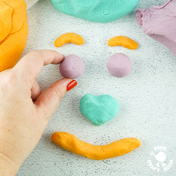 No Cook Playdough shaped into a face on a tabletop.