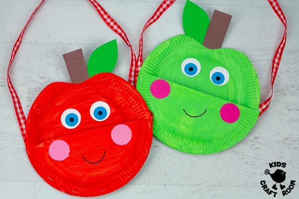 A red and green apple bag lying side by side. They have big eyes, rosy cheeks and a smiles.