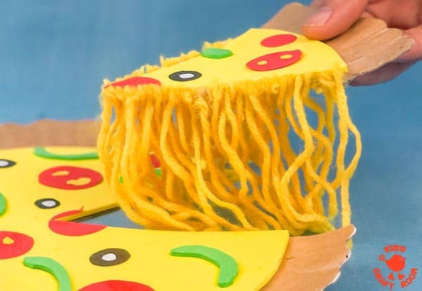 A close up of the paper plate pizza craft, showing the melted cheese made from yellow yarn.