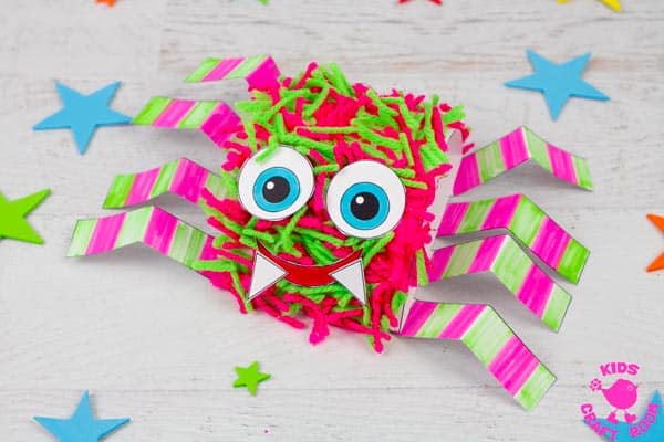 A close up of a pink and green printable hairy spider craft.