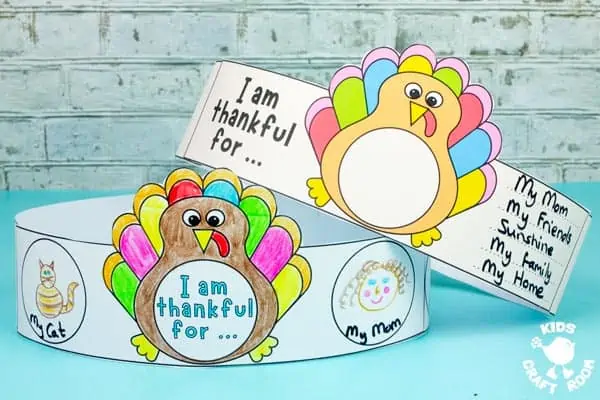 Two I Am Thankful Turkey Crowns that children have decorated stacked on top of each other.