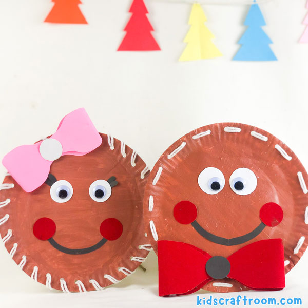 A Laced Paper Plate Gingerbread Man and Paper plate Gingerbread Girl, side by side in front of a white background.