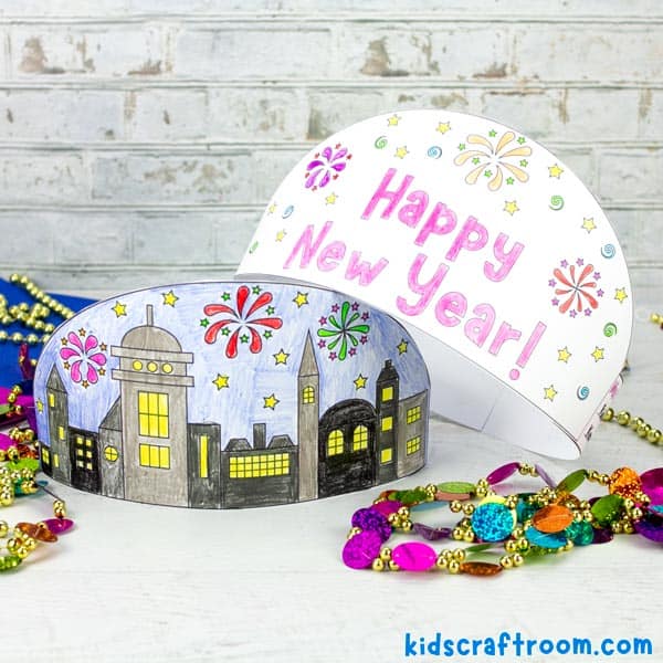 2 Printable New Year's Eve Crowns on a table. One with a cityscape design, one saying Happy New Year.