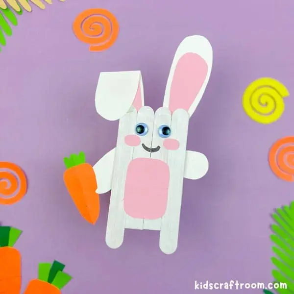 A white Popsicle Stick Easter Bunny Craft on a purple background.