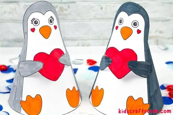 A pair of 3D Penguins holding hearts standing next to each other.