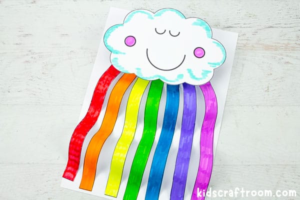 A close up of a Rainbow Cloud Craft that has been coloured in with marker pens. The cloud's eyes are shut and it is smiling.