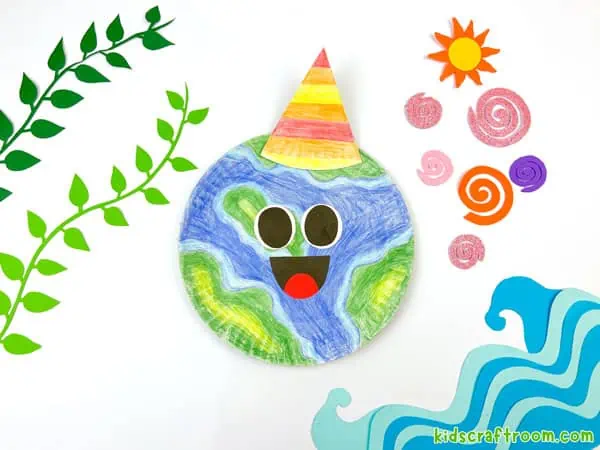 A Paper Plate Earth Day Craft on a white background surrounded by paper decorations. Green leaves on the left and a paper sun and waves on the right.