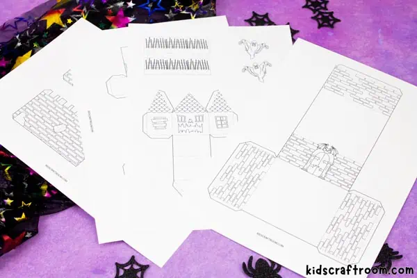 The 3D Haunted House Coloring Pages fanned out on a purple tabletop.