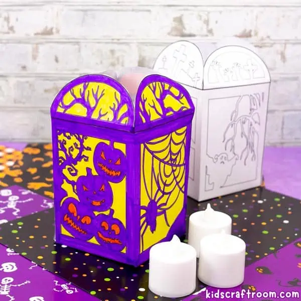 2 paper Halloween lanterns. One has been coloured in with purple and yellow markers and the other is a plain undecorated black and white design featuring a ghost.