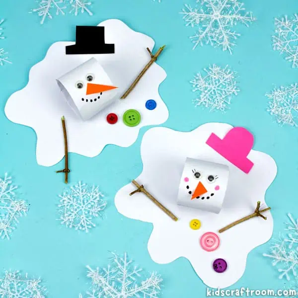 Two melting snowman crafts on a blue background surrounded by faux snowflakes. The snowmans' heads are made of white cardboard tubes and the melted bodies are made of paper. They have googly eyes, a paper hat and nose, buttons and stick arms. 